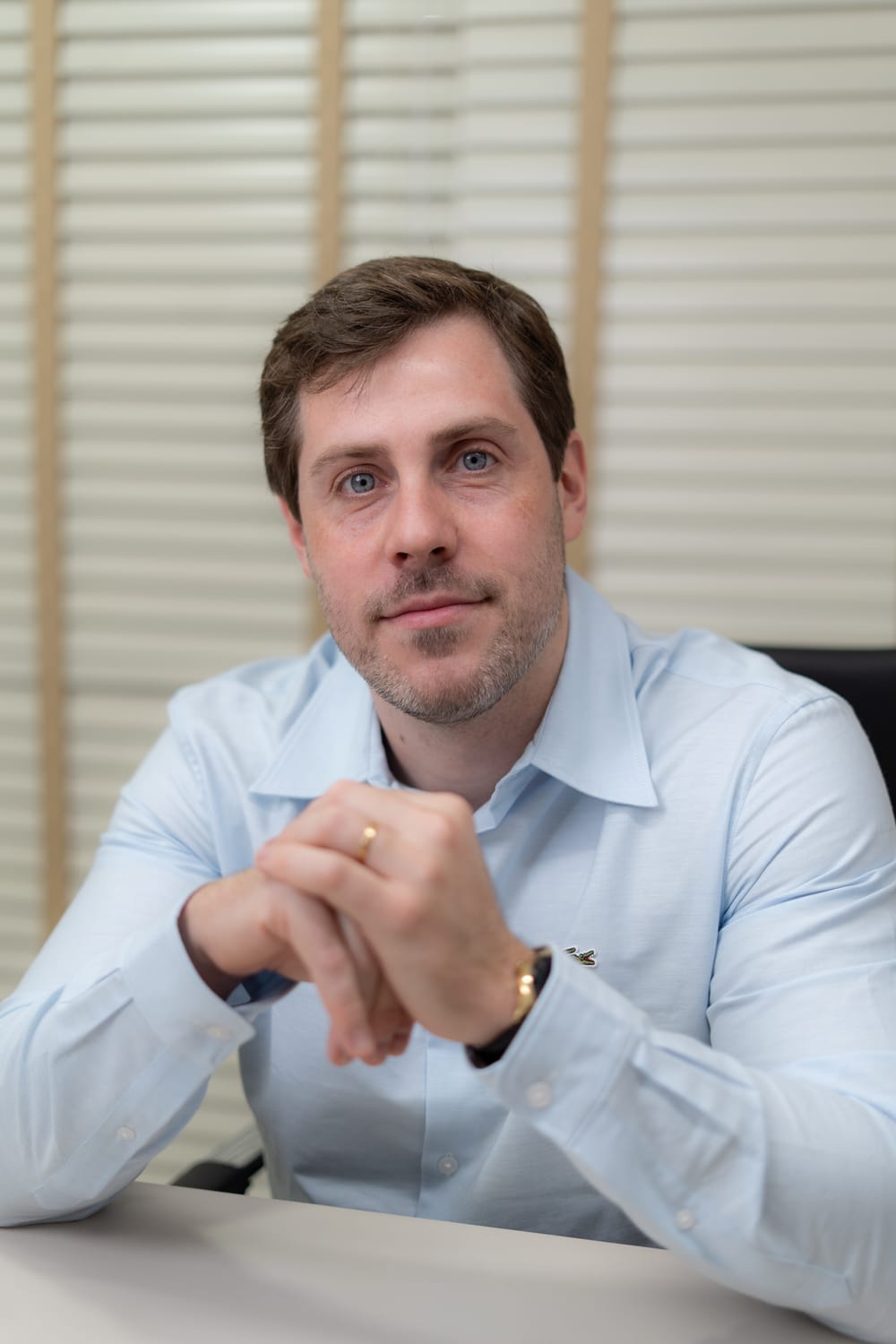 Dr. Fernando Hehn à mesa do consultório, com as mãos entrelaçadas, pronto para a avaliação
