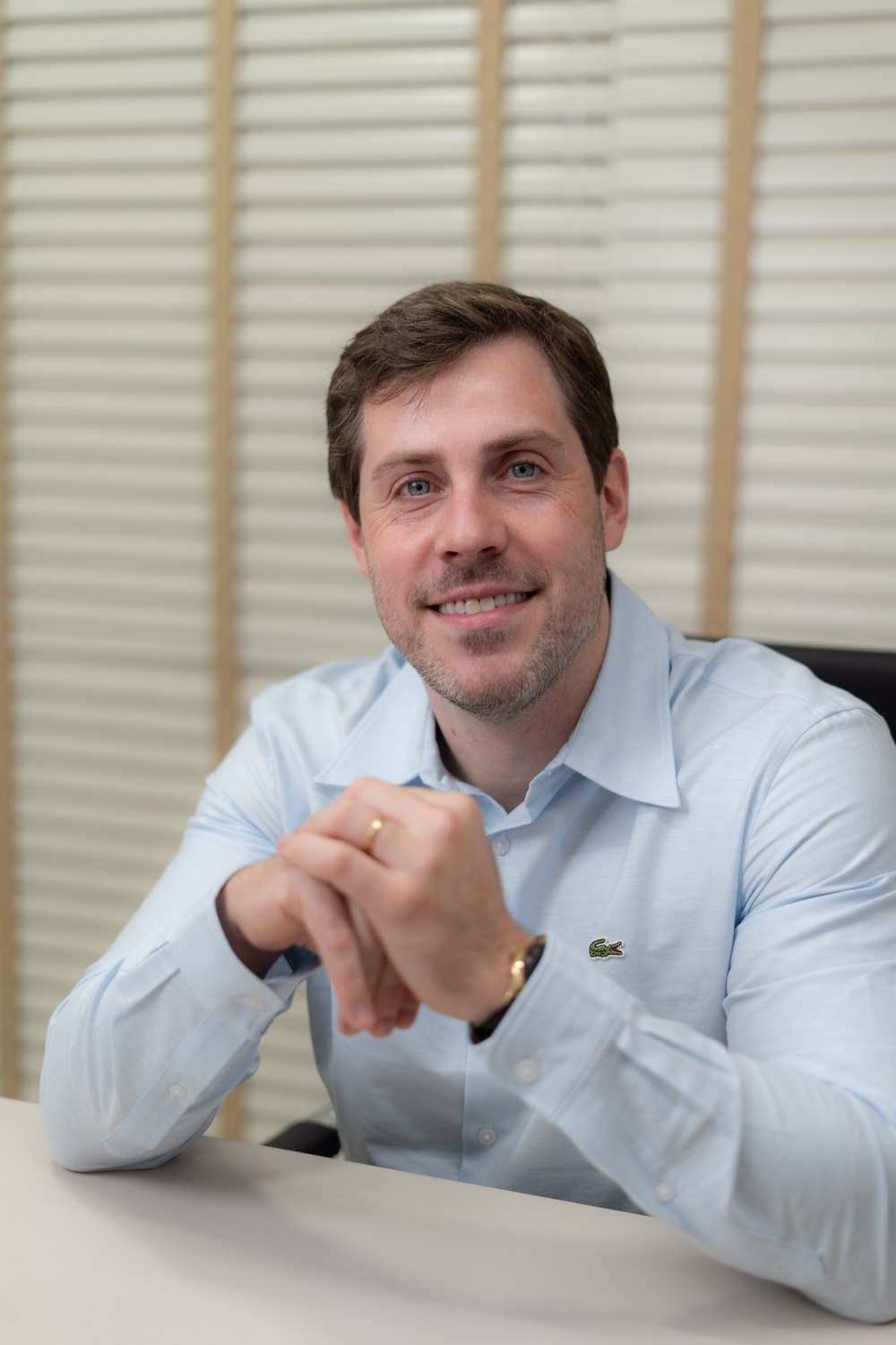 Dr. Fernando Hehn sorrindo, com as mãos entrelaçadas, olhando para a frente